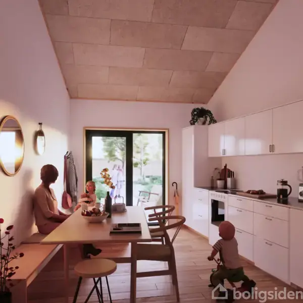 Kvinden og barnet sidder ved spisebordet i et lyst køkken. Store glasdøre fører ud til haven. Køkkenet har hvide skabe og moderne indretning. På bordet står friske blomster.