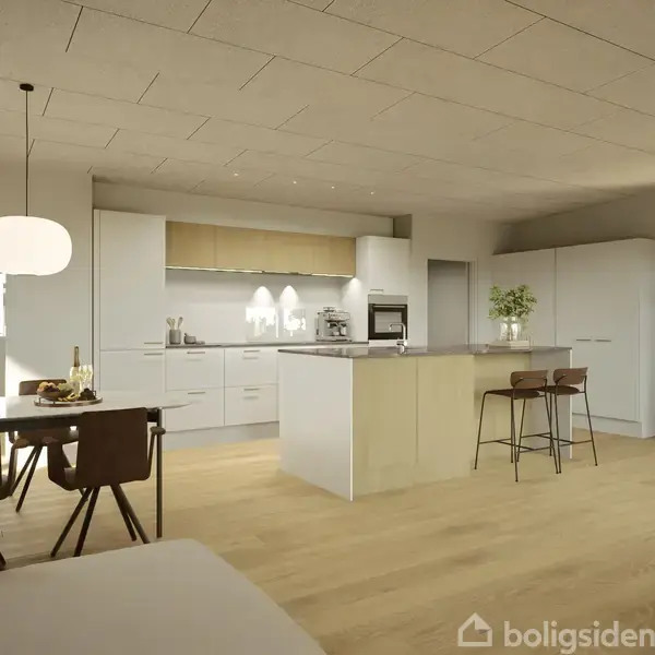 Et moderne køkken med en central køkkenø omgivet af hvide skabe. En spiseplads med bord og stole står til venstre, og rummet er lyst med træbjælkelofter.