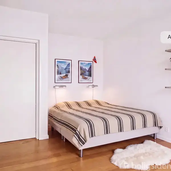 Et tomt rum med et træparketgulv og en stor, rektangulær vindue, der viser udsigt til grønne træer udenfor. Væggene er hvide, og der er en radiator under vinduet.