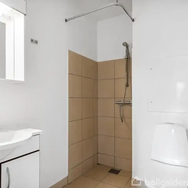 Et badeværelse med bruser i hjørnet, beige fliser, håndvask med spejl til venstre og et toilet til højre, i et hvidt rum.