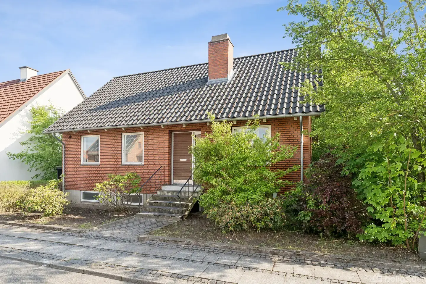 Byhus med flotte plankegulve og en skøn lukket have.