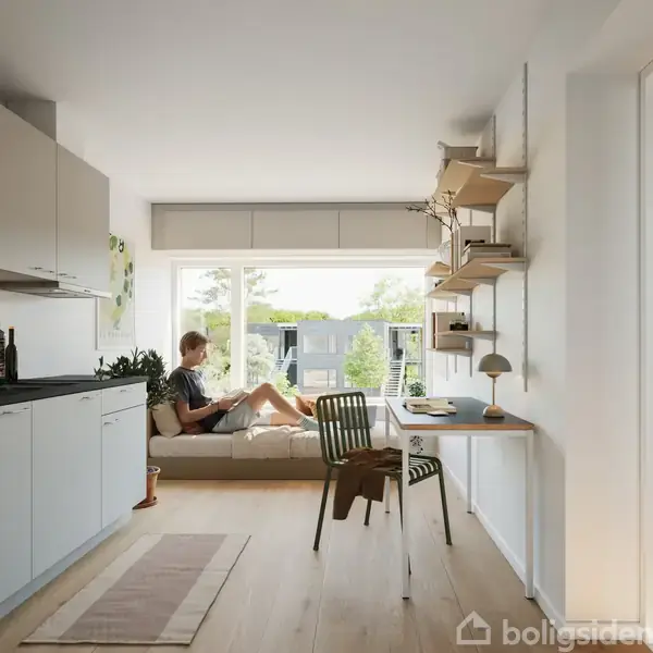 En person sidder ved et skrivebord og skriver i en notesbog. Ved siden af er en bærbar computer og en lampe. Rummet har et stort vindue med udsigt til træer og bygninger.