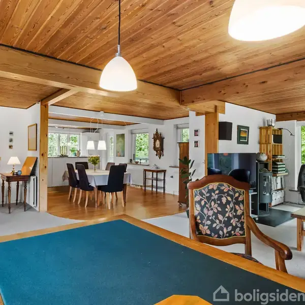 Plantegning viser en fler-etagers bygning med mærkede rum som stue, køkken og badeværelser. Inddeling af kælder, stue, og første sal er tydelig. Kompasrose findes i øverste højre hjørne. Tekst: "Vejledende tegning uden ansvar."