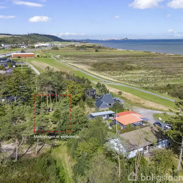 Skovområde omringet af markeret felt i rød stiplet linje. Vej og huse tæt ved stranden og åbent landskab. Tekst: "Markeringen er vejledende".
