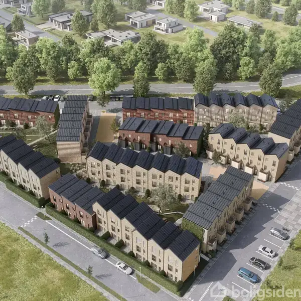 Rækkehuse står i en U-formet formation. Tagene er mørke, mens facaderne varierer i nuancer. Omkring ses frodige træer og grønne områder samt parkerede biler på asfalterede veje.