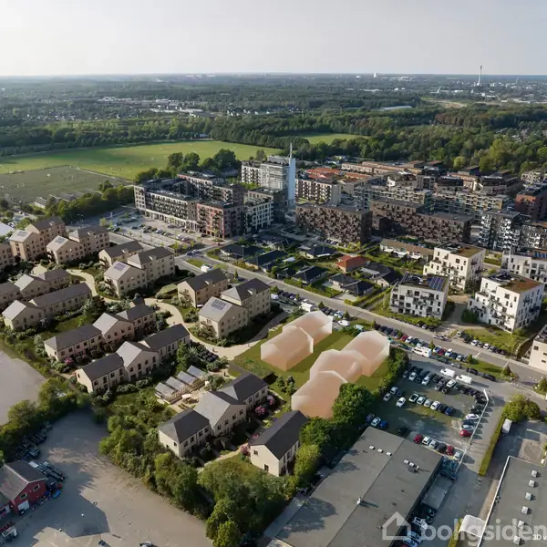 En moderne boligblok ligger stille omgivet af træer og græsarealer i et forstadsområde. Omkringliggende bygninger og en parkeringsplads fuldender scenen, med byens horisont i baggrunden.