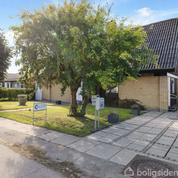Huset er en gulstensvilla med skråt tag i en forstad. Villaen har en garage og er omgivet af en have med store træer. Der er en flisebelagt indkørsel.
