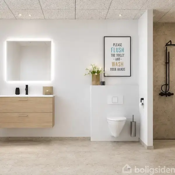 Håndvask med spejl lyser op under belysning; toilettet monteret ved siden af med en planter og skilt, "PLEASE FLUSH THE TOILET AND WASH YOUR HANDS", en bruser til højre i moderne badeværelse.