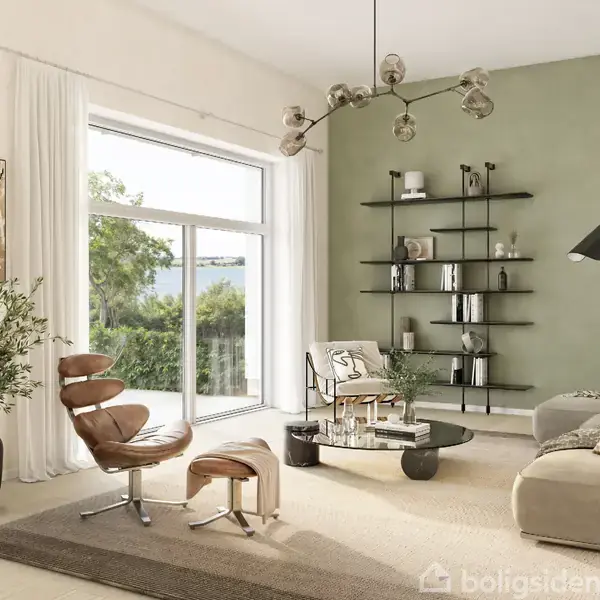 Lænestol står i stue ved vindue, omgivet af grøn væg, sofabord, sofa, hylder, og planter. Rummet er lyst og moderne med lyse gardiner og neutrale farvetoner.