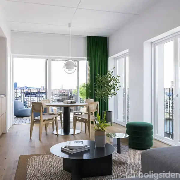 Stue med moderne indretning, hvor et rundt spisebord med stole står ved store vinduer med udsigt. Grønne planter og en sort sofabord komplimenterer rummet. Lyse trægulve og køkken til venstre.