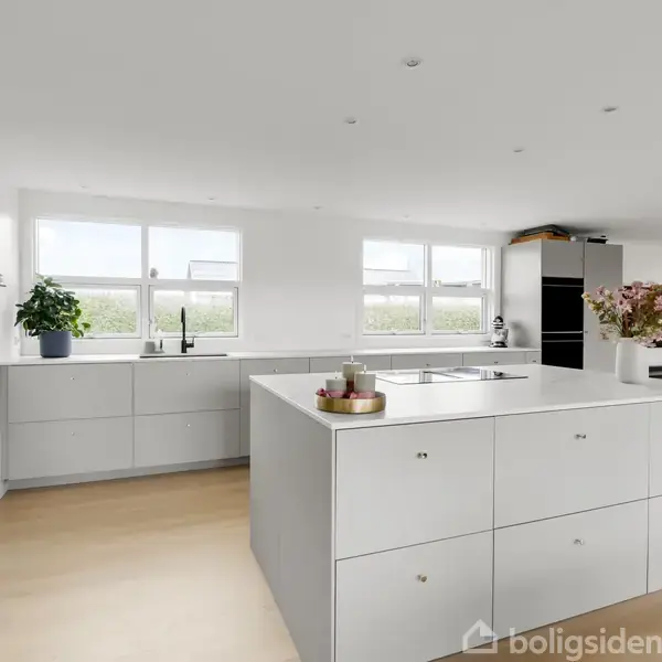 Køkkenskab står centreret, omgivet af hvide vægge og lyse trægulve; en stor køkkenvask og dekorationer ovenpå, med vinduer bagved, der viser landskabet udendørs.