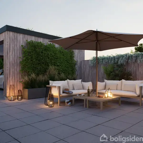 Terrassemøbler under en stor parasol, placeret på en flisebelagt terrasse. Sofasæt suppleret med lys i lanterner om aftenen. Baggrund med træbeklædte vægge og planter, solnedgang ses.