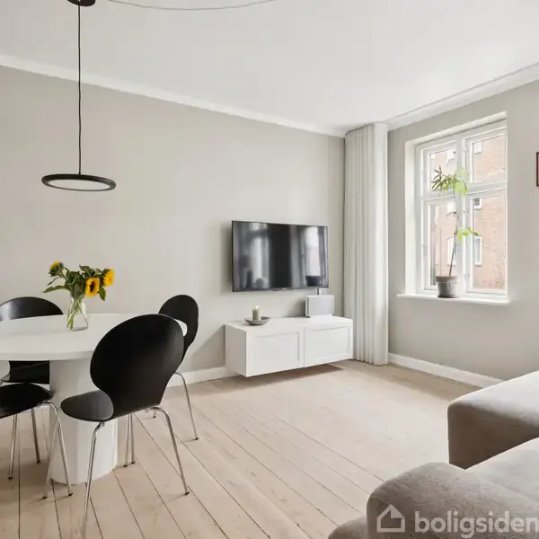 Spisebord med sorte stole står i et lyst, moderne stueområde. En vase med blomster er på bordet. Fjernsynet hænger på væggen. Trægulv og to vinduer med gardiner til højre.