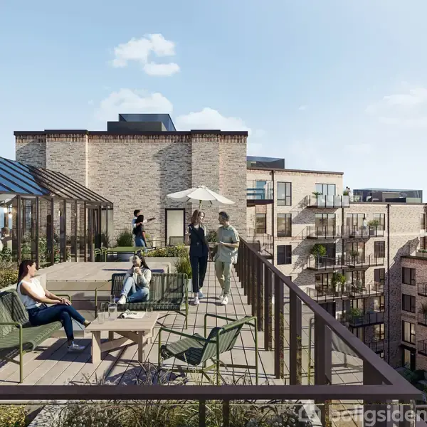 En gruppe mennesker nyder solen på en tagterrasse med moderne møbler og planter. I baggrunden ses flere etageejendomme af mursten og en klar himmel.