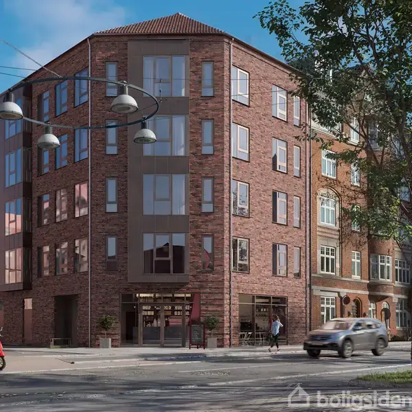 En rød murstensbygning med store vinduer står på et hjørne. En person kører på scooter, mens en bil passerer i vejkrydset. Træer og lamper omkranser området.