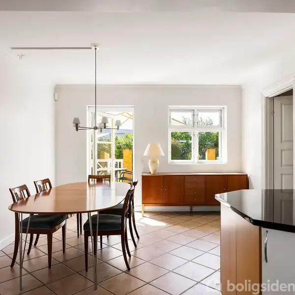 Et spisebord med seks stole står i et rum med lyse vægge og terrakotta-flisegulv. To vinduer bagest slipper sollys ind, og en skænk står ved væggen.