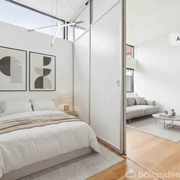 Soveværelse med dobbeltseng dækket af hvidt sengetøj, værelse adskilt fra opholdsstue af skydedør; gulvlaminat og kunst på væggen. Soveværelset er lyst og minimalistisk. Tekst: "AI visualisering".