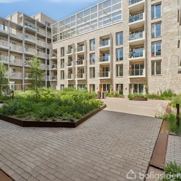 Boligkompleks med et moderne design; omfatter en centralt beliggende, flisebelagt gårdhave med planter i forhøjede bede. Omkringliggende lejligheder har store vinduer og altaner.