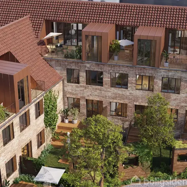 Bygning med murstensfacade og rødt tegltag, har terrasser og vinduer i flere plan. Omgivet af grønne træer og planter, der skaber en frodig gårdhave mellem husene.
