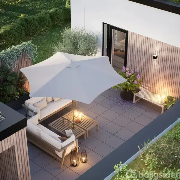 En terrasse med loungeområde indeholder en hvid parasol, sofaer og små borde med lanterner. Der er planter omkring, og en dør fører ind til huset med træbeklædning på væggen.