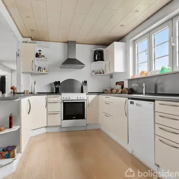 Køkken med lyse skabe, komfur og emhætte. Aktionen er opbevaring og madlavning. Konteksten inkluderer store vinduer, træloft, og åbne hylder med krydderier.