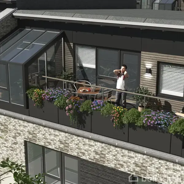 Manden står på en blomsterfyldt altan og taler i telefonen. Baggrunden viser en moderne bygning med store vinduer og mursten.