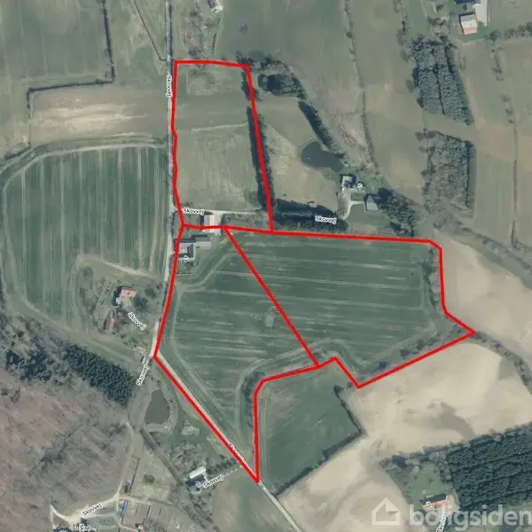 Et landbrugsområde er indrammet med en rød konturlinje og omfatter marker med afgrøder. Omgivelserne består af flere åbne marker, skovområder og få bygninger spredt rundt i landskabet.