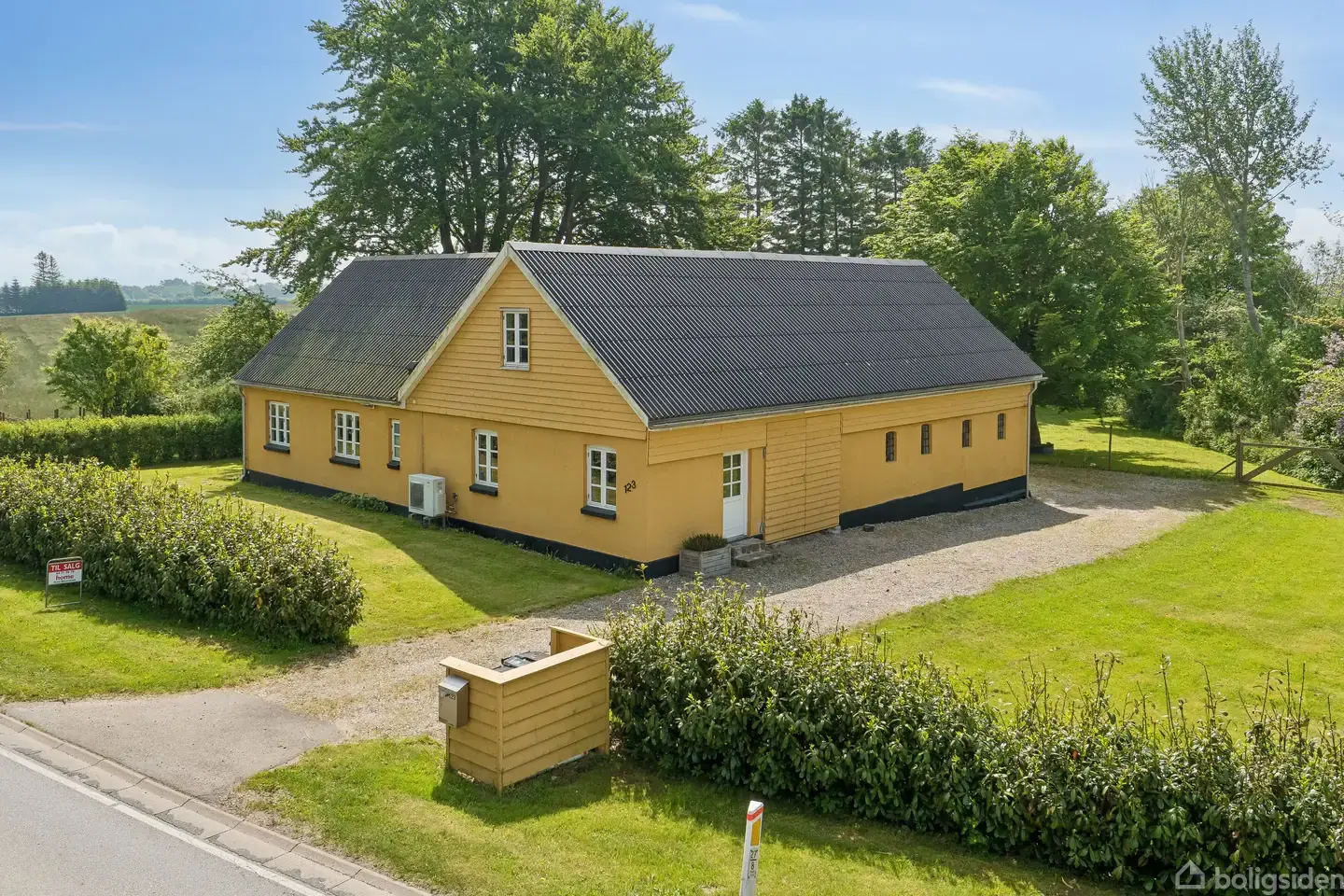 Moderniseret landejendom med udsigt over åbne marker.
