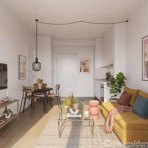 Stue med en gul sofa fyldt med puder og et tæppe, placeret ved siden af et sofabord med blomster. På væggen hænger kunst, og spisestuemøbler står tæt ved.