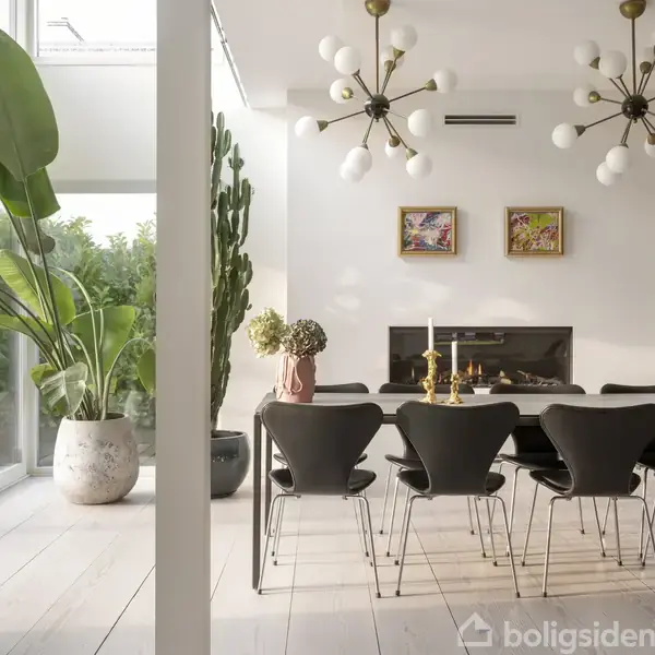 Spisebord med otte sorte stole står i en lys spisestue. To moderne lysekroner hænger over bordet. Store planter placeres ved glasvægge, og to kunstværker hænger på væggen.
