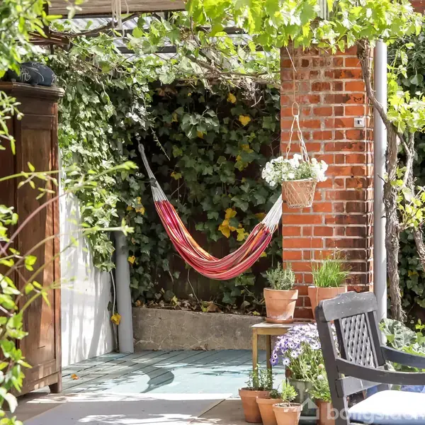 Hængekøje hænger stille mellem murstensvægge og grønne planter; omringet af potteplanter, en bænk og en hyggelig, skyggefuld terrasse.