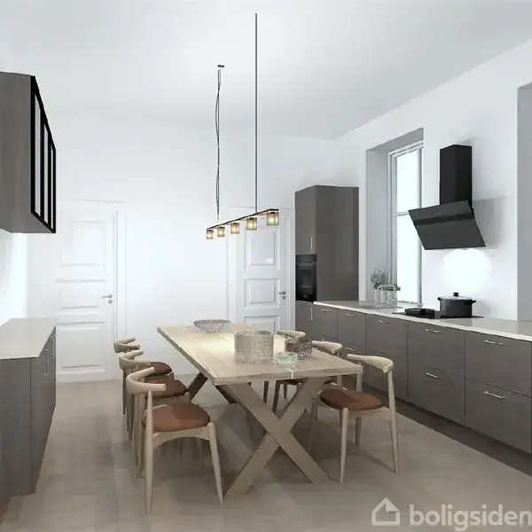 Et moderne køkken med et stort træbord og seks stole står centralt. Køkkenet har grå skabe, en ovn og emhætte, og der hænger en lampe over bordet i en lys, minimalistisk indretning.