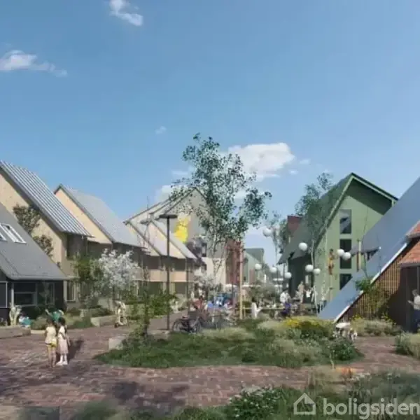 Moderne rækkehuse med skråtstillede tage står langs en brostensbelagt gade. Mennesker spadserer og socialiserer i et grønt, urbant boligområde med små haver og træer under en blå himmel.