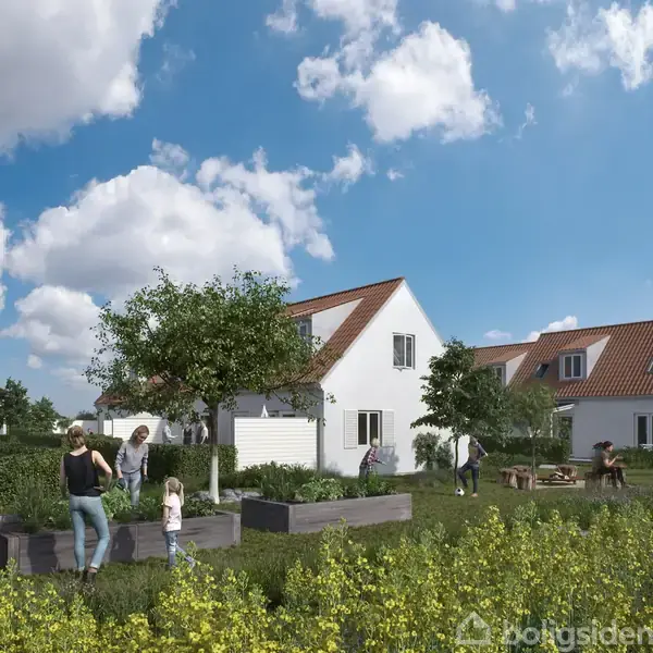 En gruppe mennesker arbejder i en have, omgivet af grønne planter og træer, foran flere hvide huse med røde tegltage under en blå himmel med hvide skyer.