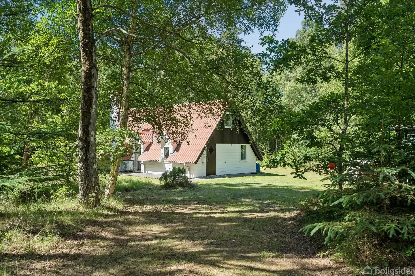 Stort sommerhus tilbagetrukket fra vejen på stor naturgrund