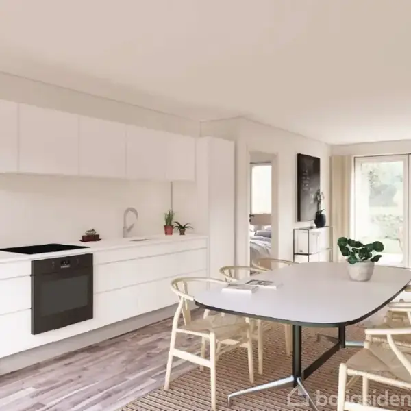 Et lyst køkken med hvide skabe og en indbygget ovn. Et spisebord med stole står i centrum. Store vinduer åbner ud til en grøn have.