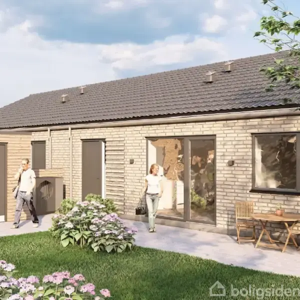 En rækkehusbygning med murstensfacade og mørkt tag omgivet af en velplejet græsplæne med blomsterbede. Mennesker går eller står udenfor, og et havebord med stole står på terrassen.