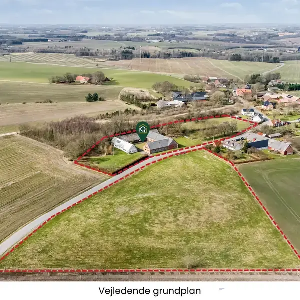 Et landligt område omkranser en gruppe bygninger indrammet af røde linjer. Området er stort og inkluderer marker og spredt bebyggelse. Teksten "Vejledende grundplan" vises nederst.