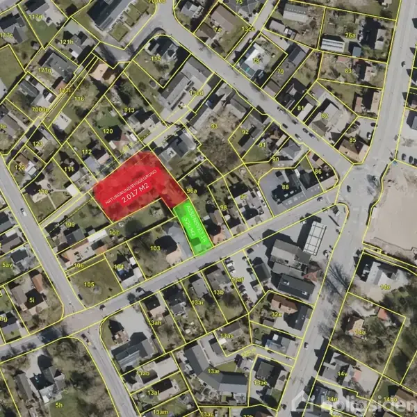 Luftfoto af et beboelsesområde med gule linjer, der markerer ejendomsgrænser. En rød sektion er markeret som "702 m2", og en grøn sektion som "243 m2".