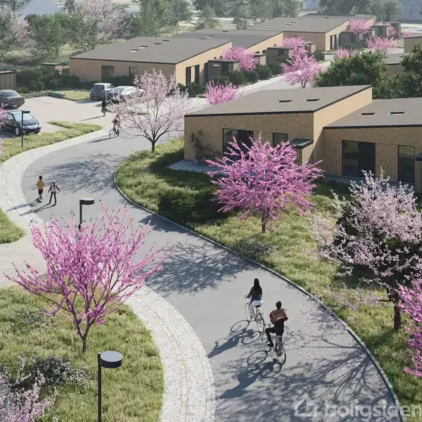 Flade hustage omgivet af blomstrende kirsebærtræer, mennesker cykler og går langs en snoet vej i et boligkvarter. Sollys fremhæver de lyserøde blomster og grønne omgivelser.