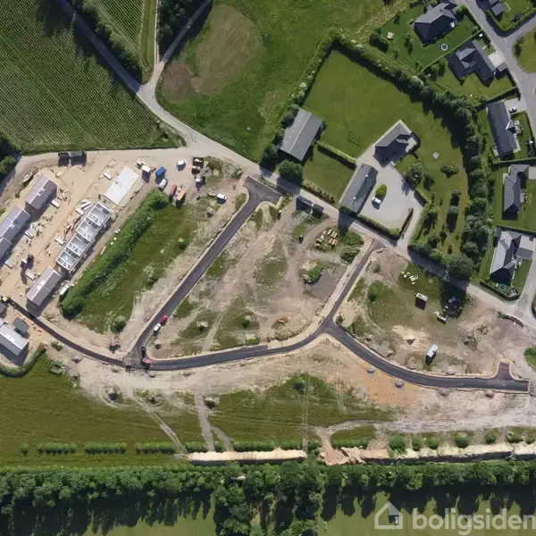 Bygningskonstruktion under udvikling. Området indeholder flere veje og strukturer i et grønt landskab, med færdige huse i nærheden. Boligsiden-mærke nederst til højre ignoreres.
