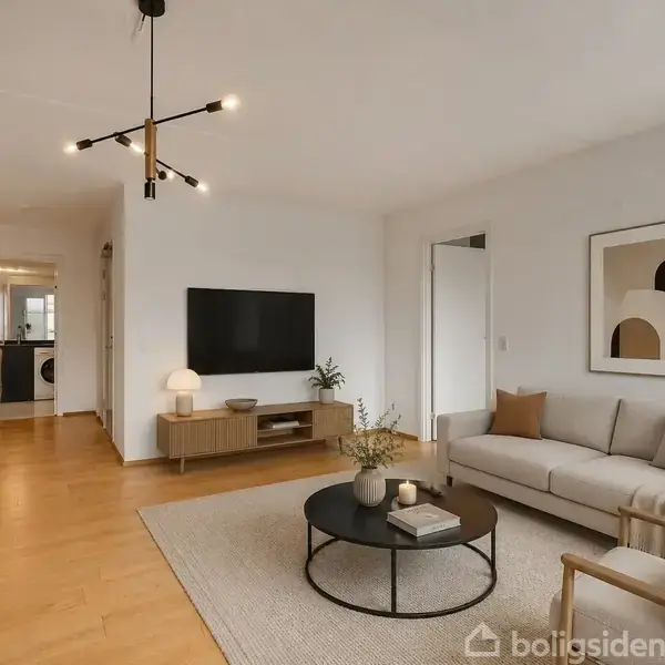 Stue med beige sofa og lænestol omkring et rundt sofabord, fladskærms-tv på væggen. Moderne loftslampe, trægulv, og planter som dekoration. Tekst: "Visualisering".