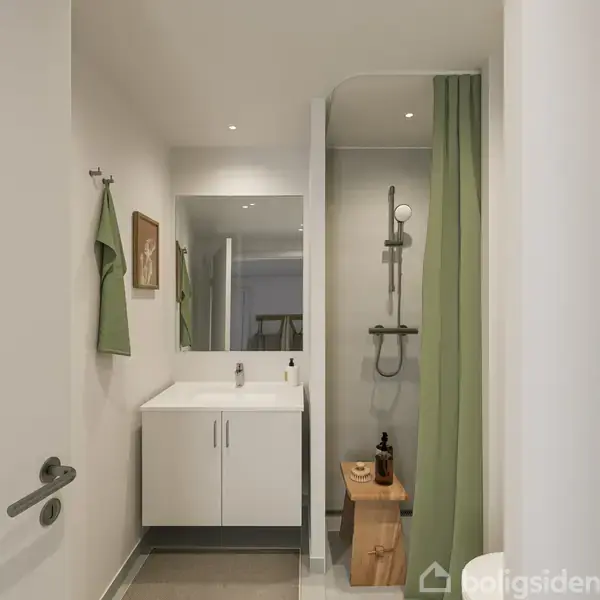 Håndvask med spejl i moderne badeværelse, håndklæder hænger på væggen, bruseniche til højre med grønt forhæng, enkel og stilren indretning.