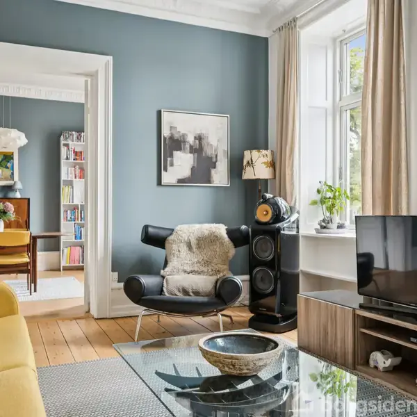 En moderne stue med gul sofa og lænestol, placeret foran et fjernsyn. Rummet har blå vægge og trægulv. Et stort vindue med gardiner giver lys. I baggrunden ses en spisestue.