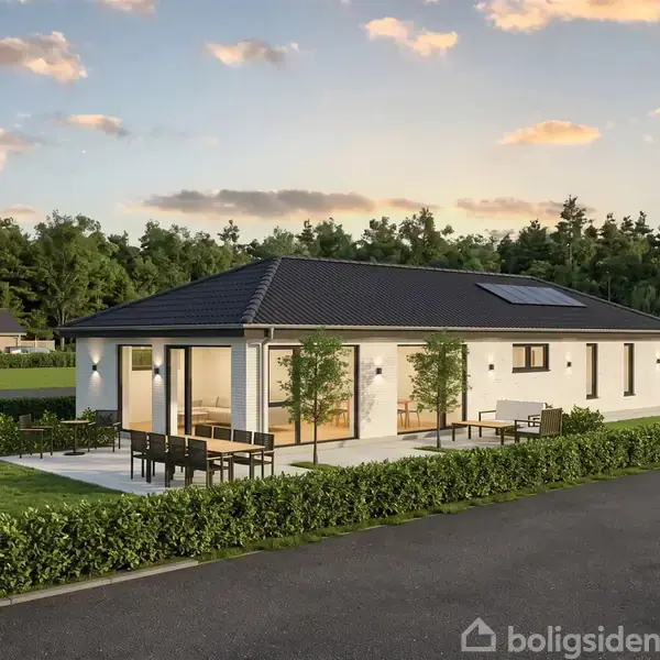 En moderne én-etagers villa med fladt tag og store vindueselementer. Villaen har en terrasse med møbler og er omkranset af en velplejet hæk. I baggrunden ses en skov og flere huse.