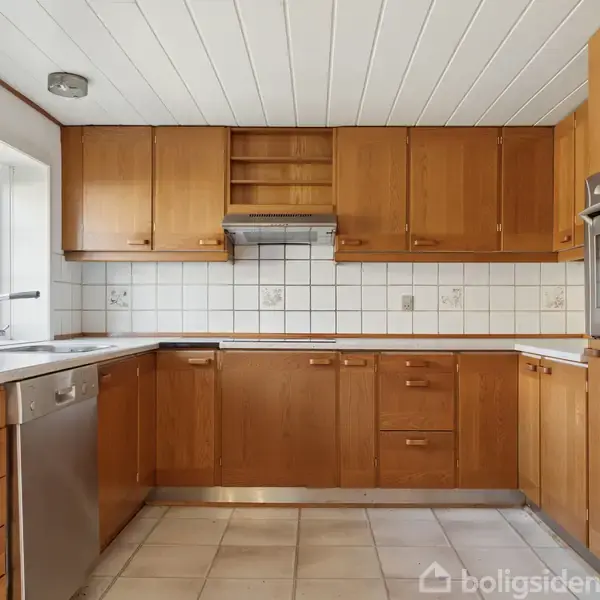 Et køkken med træskabe og skuffer, opvaskemaskine og indbygget ovn. Flisevægge danner baggrund, og en vask står under et vindue ved siden af stålbordpladen.