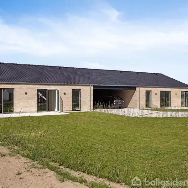 Moderne, én-etagers murstenshus med sort tag, store glasvinduer og indbygget garage med bil. Placeret i en nybygget beboelsesområde med græsplæne foran og blå himmel.