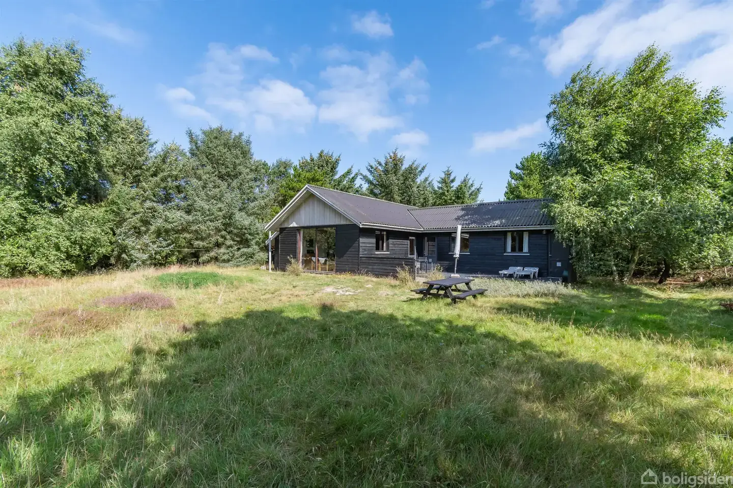 Velholdt sommerhus beliggende på en meget ugenret grund