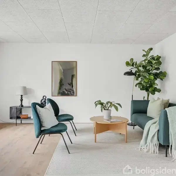 Sofa og stole i moderne stue med træbord og plante; grønne nuancer i møbler; lysindfald fra store vinduer; neutral vægfarve; gulvlampe og vægdekoration.