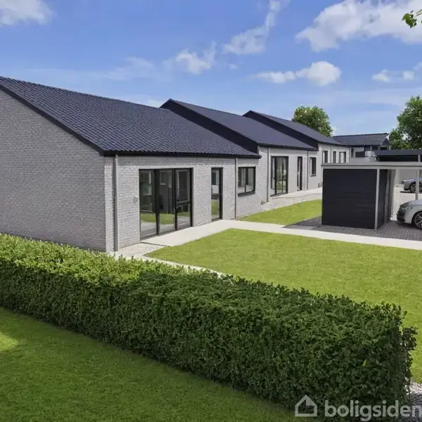 En rækkehusbygning med mørkt tag og lyse ydermure står stille. Foran er en velplejet græsplæne med en hæk. To biler holder parkeret under en carport i baggrunden.